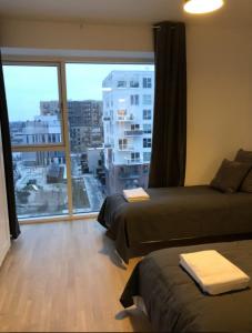 a room with two beds and a large window at Modern Spacious 3 Bedroom Apartment With Balcony At Richard Mortensens Vej Close To The Royal Arena And Fields in Copenhagen