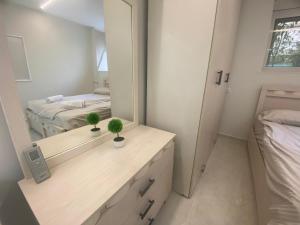 Dormitorio con tocador con espejo y cama en דירת בוטיק - Boutique apartment en Bayit Wegan