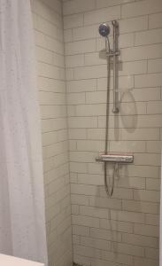 a shower with a shower head and a shower curtain at Modern Spacious 3 Bedroom Apartment With Balcony At Richard Mortensens Vej Close To The Royal Arena And Fields in Copenhagen