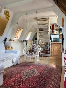 ein Wohnzimmer mit einer weißen Couch und einer Leiter in der Unterkunft Petite city center loft on Amstel river in Amsterdam