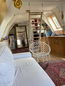 ein Wohnzimmer mit einem weißen Bett und einem Stuhl in der Unterkunft Petite city center loft on Amstel river in Amsterdam
