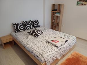 un letto con lenzuola e cuscini bianchi e neri di Bulrock Residance a Sofia
