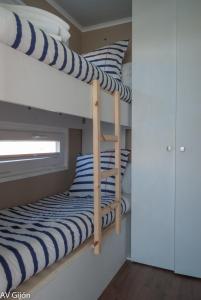 two bunk beds with blue and white striped pillows at AV Amsterdam Casa Flotante in Gijón