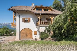 una casa grande con una gran puerta de madera en Weingartnerhof Calendula en San Genesio Atesino