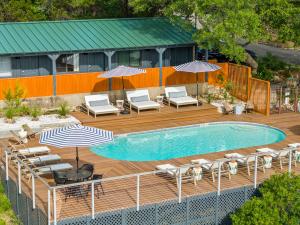 a pool with chairs and umbrellas on a wooden deck at The Bygone in Wimberley