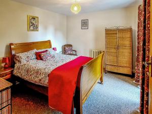 a bedroom with a bed with a red blanket at Littlecot in Wyke Regis