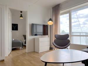 a living room with a table and a chair and a television at 3 Bedroom Apartment At Margretheholmsvej With Balcony Near The Opera House And The City Center in Copenhagen