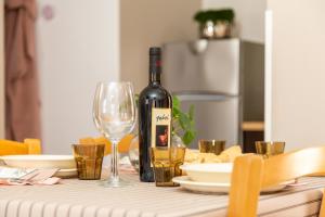 a bottle of wine sitting on a table with glasses at La casa di NONNO ELIGIO in Bari Sardo