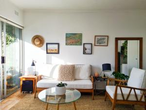 sala de estar con sofá blanco y mesa de cristal en 13 Middelhof, en Ciudad del Cabo
