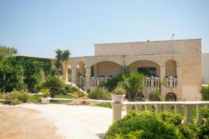 a brick building with a white fence in front of it at B&B Tenuta Martinelli in Monopoli
