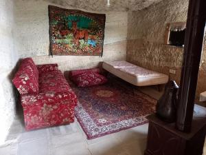 a living room with a couch and a rug at cave house(Kır evi) 