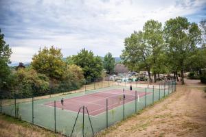 a tennis court with people playing on it at Huttopia Divonne les Bains in Divonne-les-Bains +31 photos