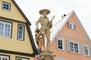 ビーティッヒハイム・ビッシンゲンにあるHotel Schillerの建物前に立つ男像