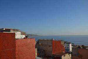uitzicht op de daken van gebouwen en de oceaan bij Private appartement in the centre of Taghazout in Taghazout