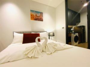 a white bed with two swans sitting on it at Edge Central Pattaya Vip Condo in Pattaya Central