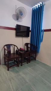 two chairs and a tv in a room at Hoàng Anh Hotel in Ho Chi Minh City