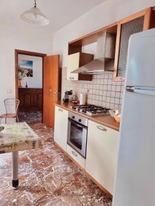 eine Küche mit einem weißen Kühlschrank und einem Herd in der Unterkunft Nel cuore di Amantea in Amantea