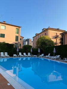 una grande piscina con sedie e un edificio di Hotel Bella Peschiera a Peschiera del Garda