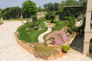 a garden with a fountain and flowers in a building at B&B Tenuta Martinelli in Monopoli