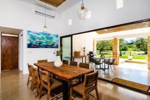 uma sala de jantar com uma mesa de madeira e cadeiras em Casa Cenizaro- 4BR House in Hacienda Pinilla em Tamarindo