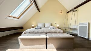 une chambre avec un grand lit dans un grenier dans l'établissement Plein Sud, appartement vue baie, accès direct plage, au Crotoy