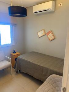 1 dormitorio con 1 cama, ventana y ventilador en Apartamento com Excelente Vista!, en Santos