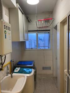 Baño pequeño con aseo y lavamanos en Apartamento com Excelente Vista!, en Santos