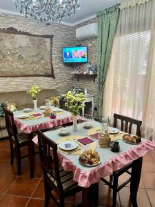 ファブリアーノにあるLa Mammola Bed&Breakfastのダイニングルームテーブル(ピンクのテーブルクロス付)