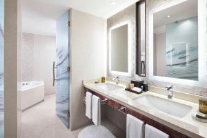 a bathroom with a sink and a mirror and a tub at Renaissance Santiago by Marriott in Santiago