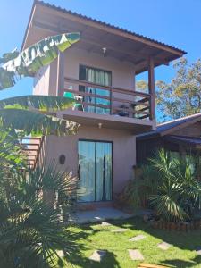 a house with a balcony and some plants at Chalés Praia do Rosa piscina compartilhada in Imbituba