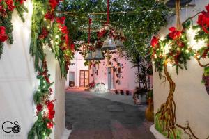 an alley with christmas decorations and a pink building at La Nghioscia in Grottaglie
