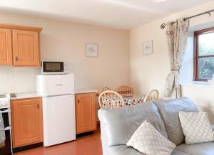 a living room with a couch and a kitchen at Coninbeg Holiday Cottage by Trident Holiday Homes in Kilmore Quay