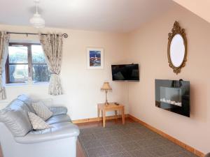 a living room with a couch and a tv at Coninbeg Holiday Cottage by Trident Holiday Homes in Kilmore Quay