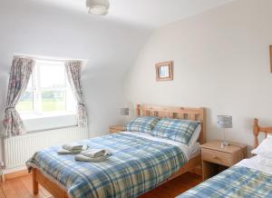 1 dormitorio con 2 camas y ventana en Coninbeg Holiday Cottage by Trident Holiday Homes en Kilmore Quay