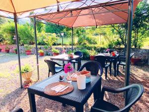 patio con tavoli e sedie sotto ombrellone di Villa Gaia a Portoferraio