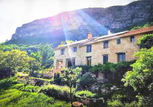 a stone building with a rainbow in the background at Private room with stunning view Gorges du Verdon in Castellane