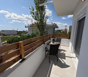 a patio with a table and chairs on a balcony at Luxury Apartment Olea Afandou in Afantou
