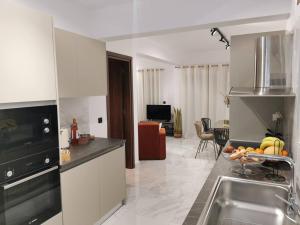 a kitchen with a sink and a table with fruit on it at Luxury Apartment Olea Afandou in Afantou