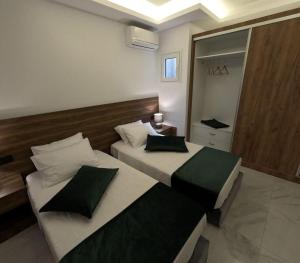 Luxury Apartment Olea Afandou في أفانتو: غرفة نوم بسريرين ومرآة