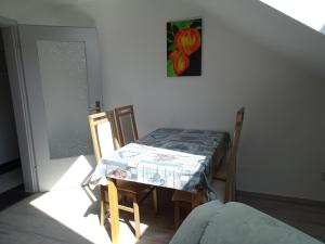 tavolo e sedie in una stanza con un dipinto sul muro di Ferienwohnung Schmidt, Wohnung 2 a Naila