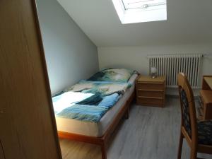 una piccola camera con letto e scrivania di Ferienwohnung Schmidt, Wohnung 2 a Naila