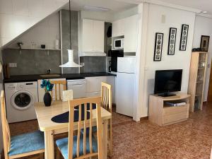 格兰阿利坎特Top-floor apartment with 65 m2 sun terrace, renovated kitchen and bathroom的带桌子的厨房和餐厅