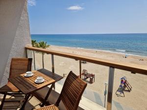 a balcony with a table and chairs and the beach at Apartamentos Wundermar in Torredembarra