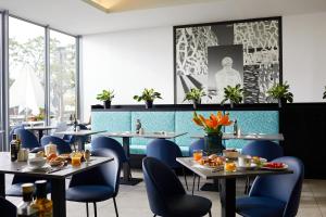 a dining room with tables and blue chairs at Royal Antibes - Luxury Hotel, Résidence, Beach & Spa in Antibes
