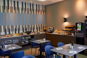 a restaurant with tables and blue chairs and a counter at Royal Antibes - Luxury Hotel, Résidence, Beach & Spa in Antibes