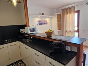 a kitchen with a counter top with a microwave at Apartamentos Wundermar in Torredembarra