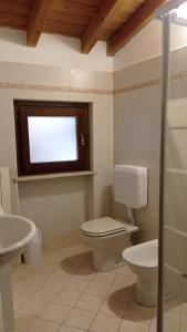 baño con aseo y lavabo y ventana en Il Fante di Picche, en Verolanuova