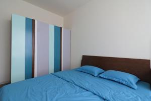 a bed with two blue pillows on top of it at Deluxe apartment with balcony, pool, fitness and yoga in Ho Chi Minh City +25 photos
