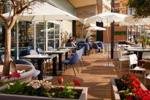 a restaurant with tables and chairs and umbrellas at Royal Antibes - Luxury Hotel, Résidence, Beach & Spa in Antibes