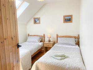 two twin beds in a room with a window at Sweetbriar Holiday Cottage by Trident Holiday Homes in Kilmore Quay
